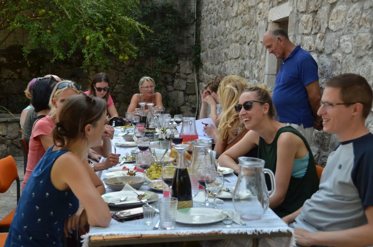 3E Travel guests sharing a long lunch with local hosts in Montenegro